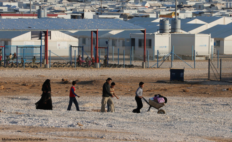 Syrian refugee family walking in camp in Jordan